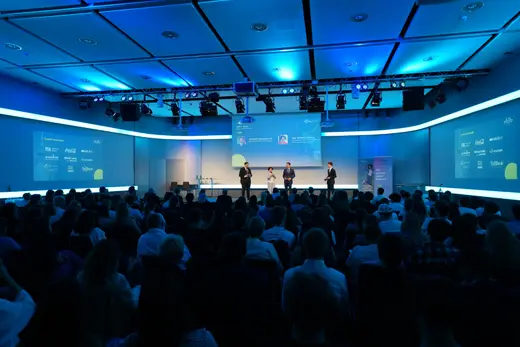 Blick über das Publikum auf die Bühne im vollen Saal