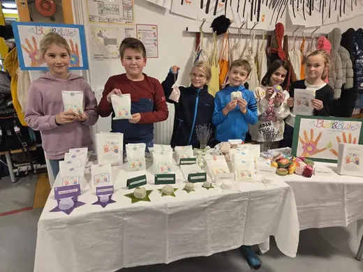 Kinder am Verkaufsstand ihrer Junior Mini Company „Blatt & Blüte“